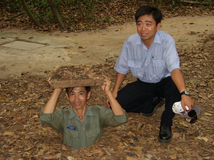 Tam And Tour Guide Demonstrating Entrance (Cu Chi Tunnels)